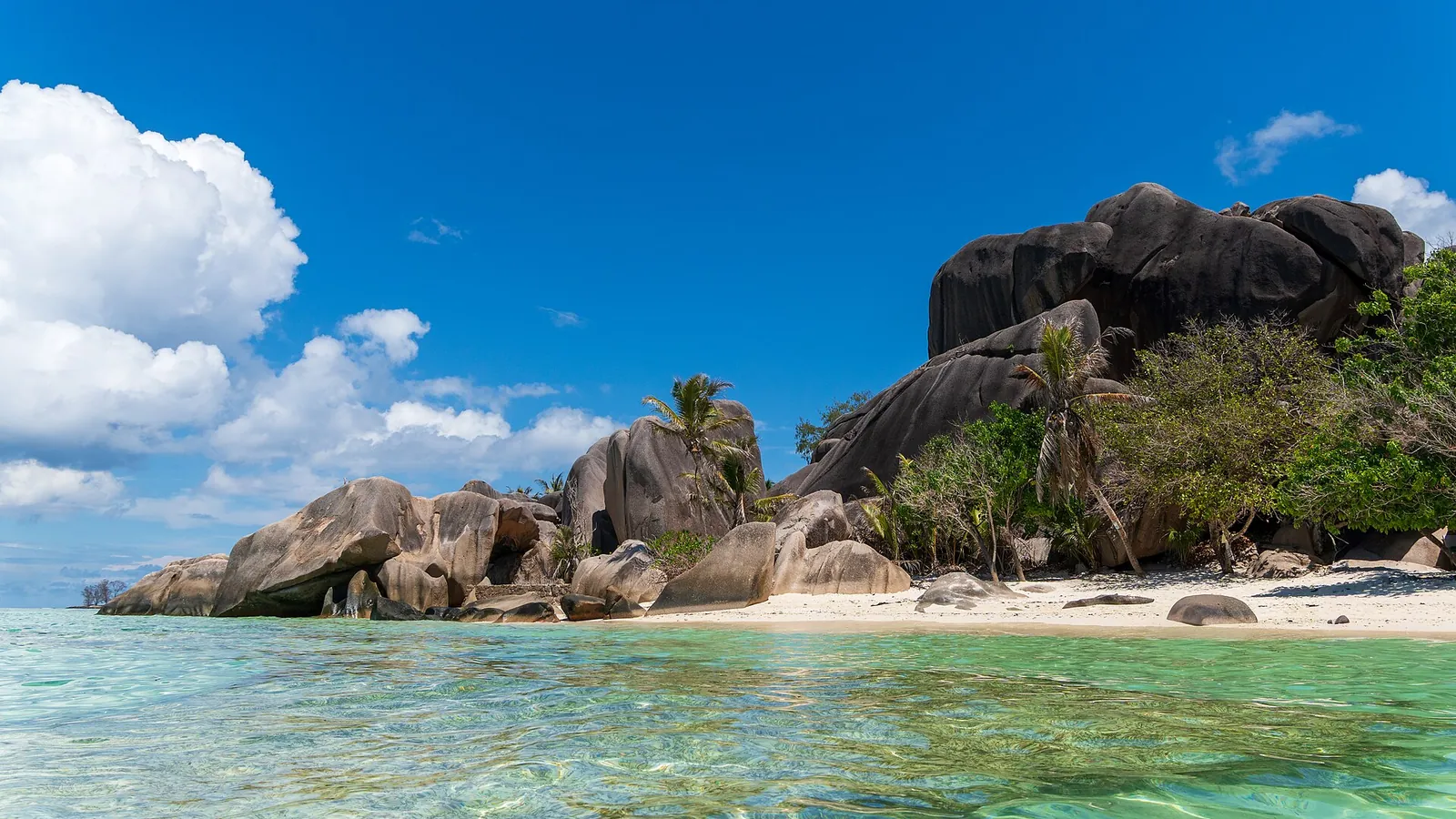 Granite boulders along a turquoise shoreline on La Digue, Seychelles