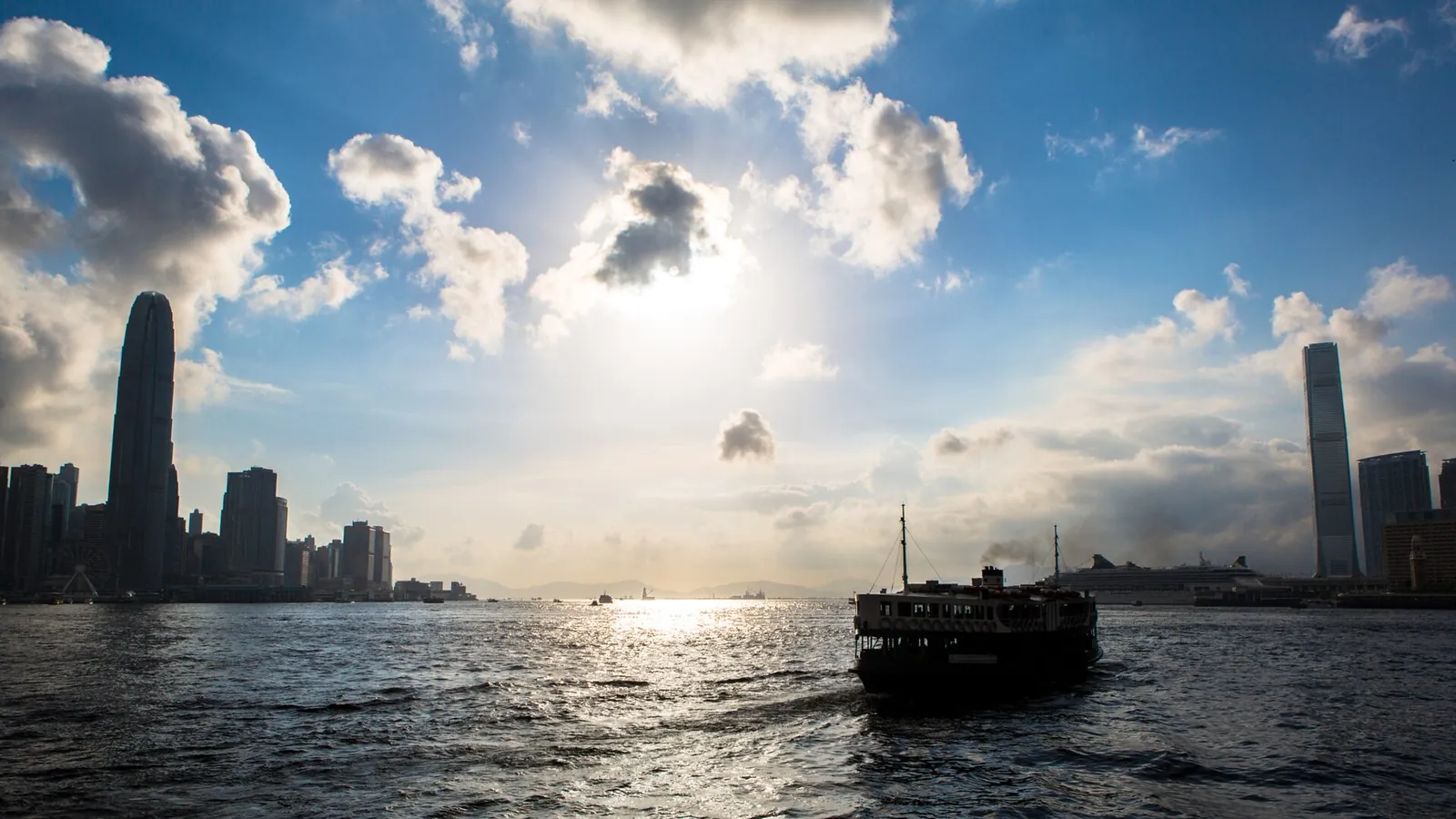 Victoria Harbour and the Hong Kong skyline under a bright sky
